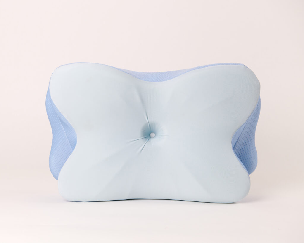 A white authentic Derila Ergo contour memory foam pillow with a butterfly structural design resting cleanly on a minimalist bed setup.